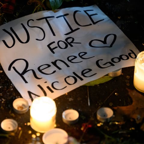 A sign reading "Justice for Renee Nicole Good" lays next to LED candles during a protest.