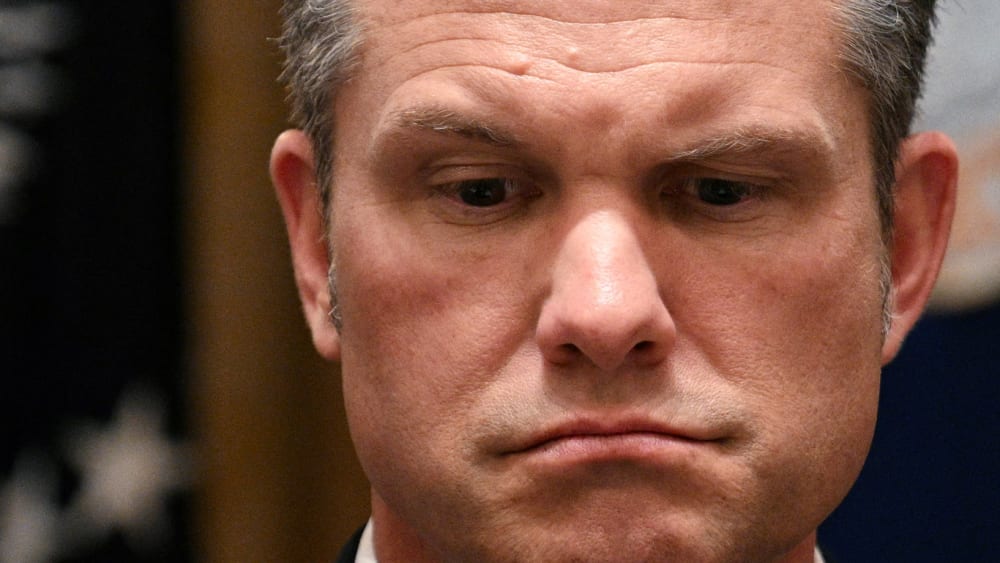 Pete Hegseth looks down.