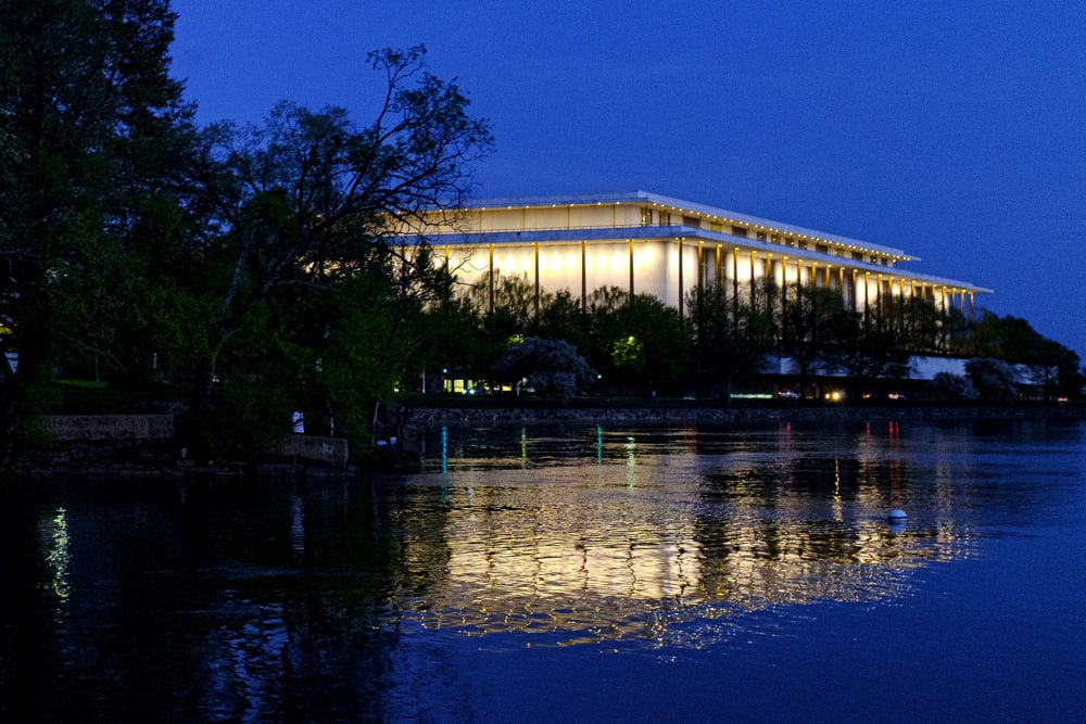 The Kennedy Center reflected in the Potomac River at dusk.