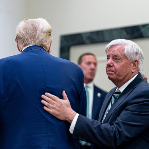 Senator Ted Cruz, left, greets Donald Trump, center, who is facing away from the camera. Lindsey Graham, right, pats Trump on the back.