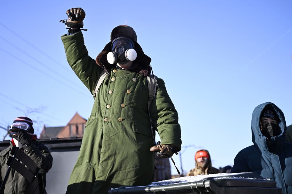 A person raises a fist as protestors confront federal agents on Jan. 24, 2026 in Minneapolis, MN.