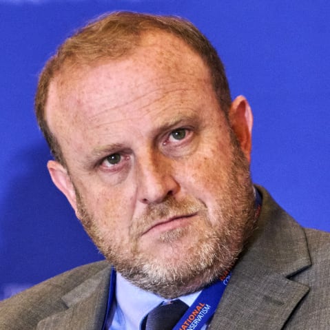 Jeremy Carl looks on in a right frame.