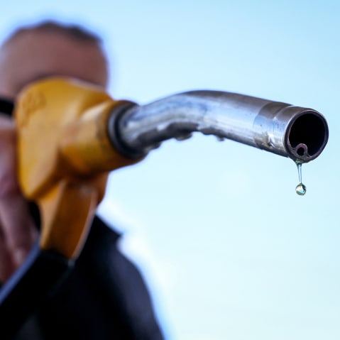 A drop of petrol falls from the nozzle of a petrol pump.