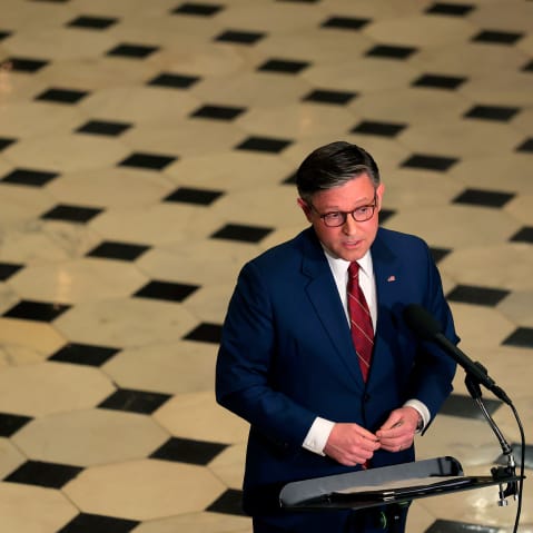 An aerial view of Speaker of the House Mike Johnson as he holds a news conference surrounded by the checkered floor of the Capitol.