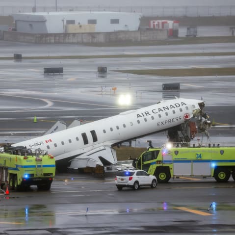 Emergency crews respond to an Air Canada Express plane on the tarmac after the plane collided with a fire truck.