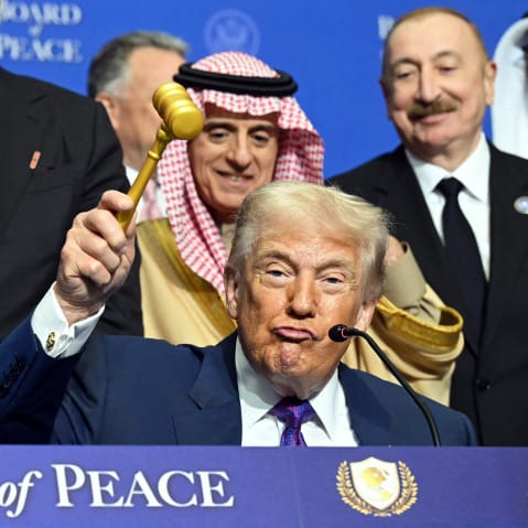 Donald Trump, center, lifts a gavel while surrounded by world leaders.