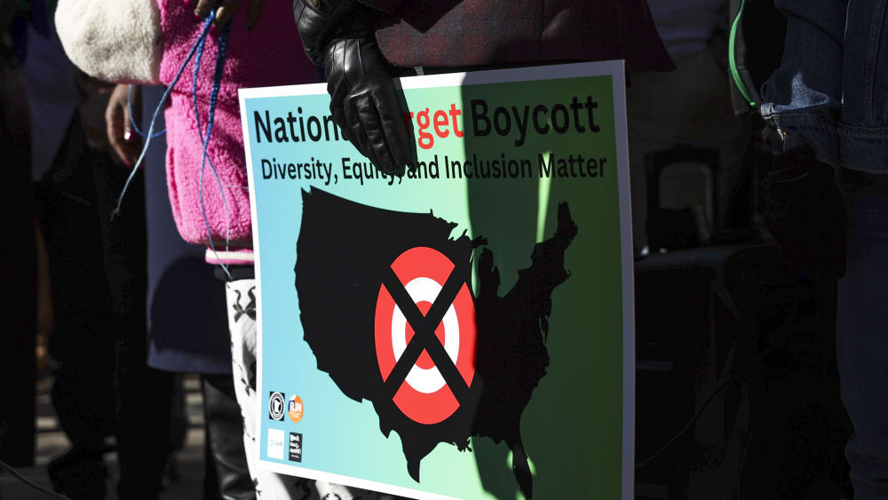 A community member holds a sign calling for a national boycott of Target stores.