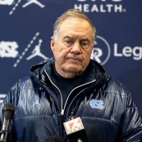 Bill Belichick looks down during a press conference.