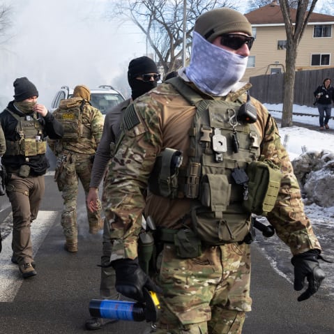 Federal agents walk in the street.