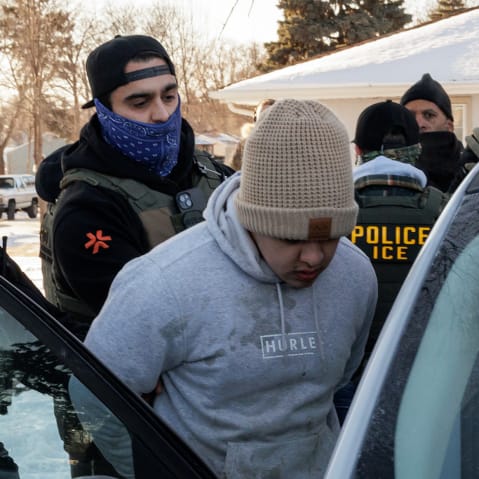Immigration and Customs Enforcement (ICE) agents detain a young man while conducting federal enforcement operations on Jan. 27, 2026 in St. Paul, Minnesota.