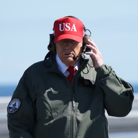 President Donald Trump observes naval flight demonstrations on the deck of the USS George H.W. Bush aircraft carrier.
