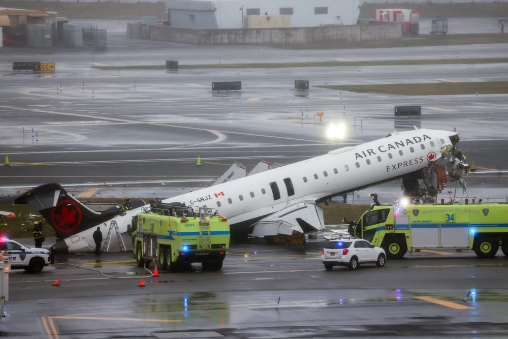 Emergency crews respond to an Air Canada Express plane on the tarmac after the plane collided with a fire truck.