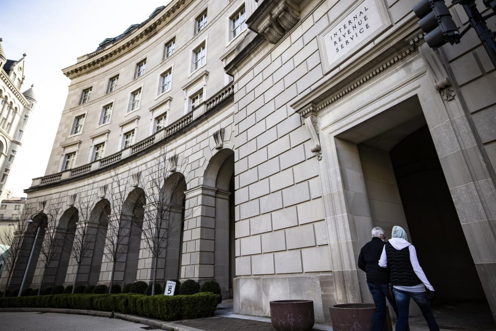 Pedestrians walk in front of the IRS headquarters on March 19, 2021, in Washington, D.C.