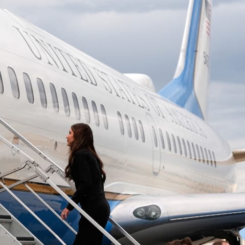 Kristi Noem walks the steps up into a plane.