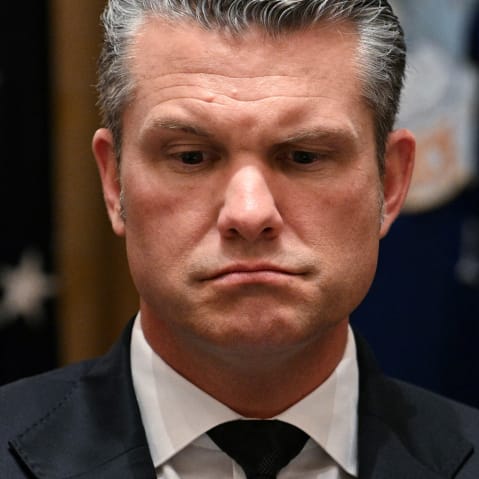Pete Hegseth looks down.