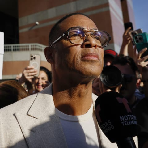 Don Lemon looks on as people protest behind him.