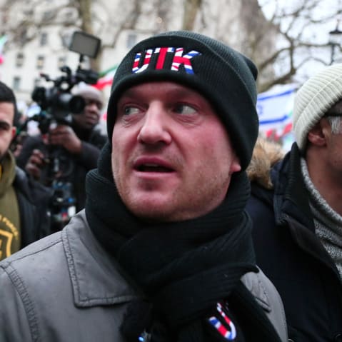 Tommy Robinson looks on as he participates in a rally outdoors in London.