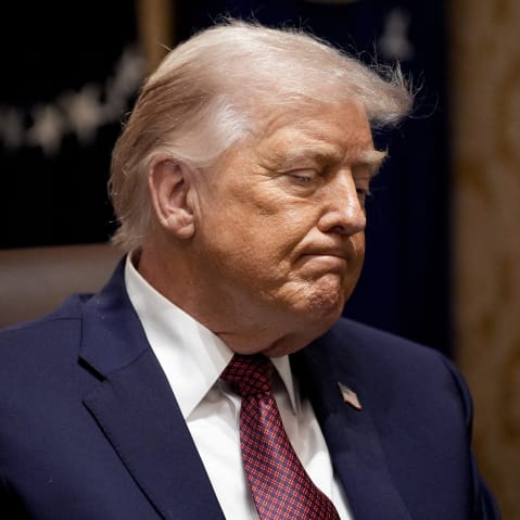 Donald Trump looks down looking upset as he sits in a meeting.