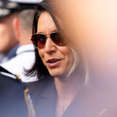 Tulsi Gabbard in sunglasses, speaking to an officer.