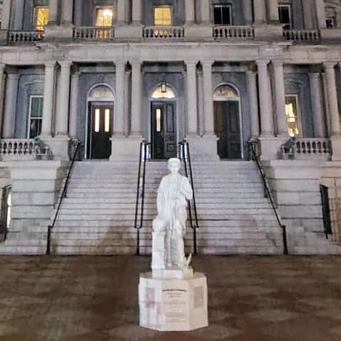 Statue of Christopher Columbus standing in front of the Eisenhower Executive Office Building.