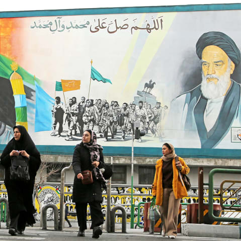 Women in Tehran walking down the street in this wide frame shot from below.