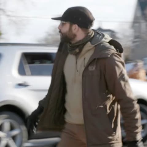 Alex Pretti is yelling at ICE agents as they drive away in their SUV. Pretti is on the right of the frame.