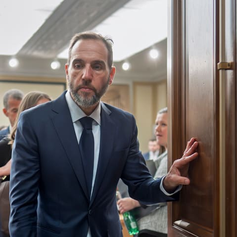 Former Department of Justice Special Counsel Jack Smith, center, walks out of a room.