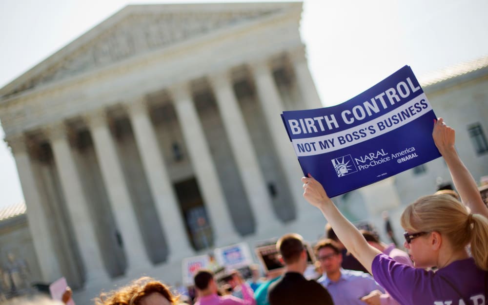 Image: A demonstrator holds up a sign outside the Supreme Court