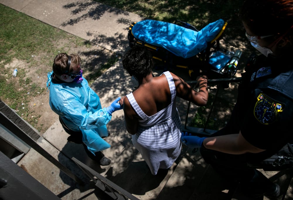 Image: Medics with Austin-Travis County EMS help a woman with Covid symptoms to a hospital in Texas on Aug. 4, 2020.