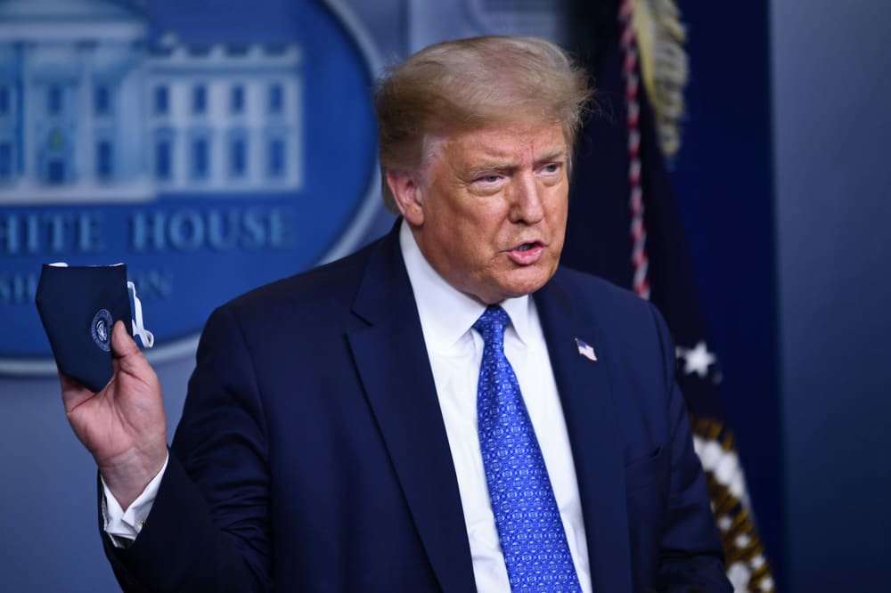 Image: President Donald Trump holds a facemask as he speaks to the press during the renewed briefing of the Coronavirus Task Force in the Brady Briefing Room of the White House.