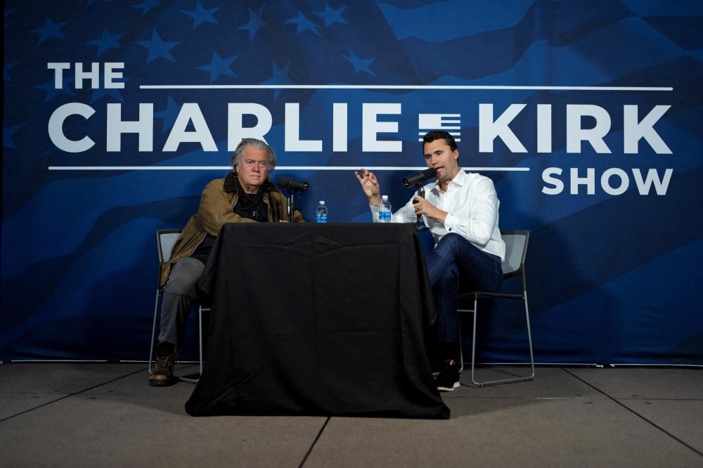 Charlie Kirk conducts a live podcast with Steve Bannon during the AmericaFest 2024 conference in Phoenix, Ariz., on Dec. 19, 2024.