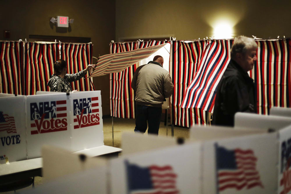 A voter steps into a voting booth to mark his ballot at a polling site for the New Hampshire primary, Feb. 9, 2016, in Nashua, N.H. (Photo by David Goldman/AP)