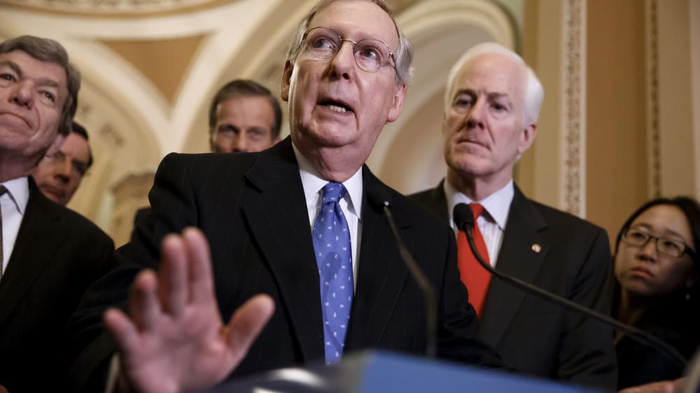 Senate Minority Leader Mitch McConnell, R-Ky., center, accompanied by fellow GOP lawmakers, speaks to reporters on Capitol Hill in Washington, Tuesday, March 25, 2014, following a GOP caucus lunch.