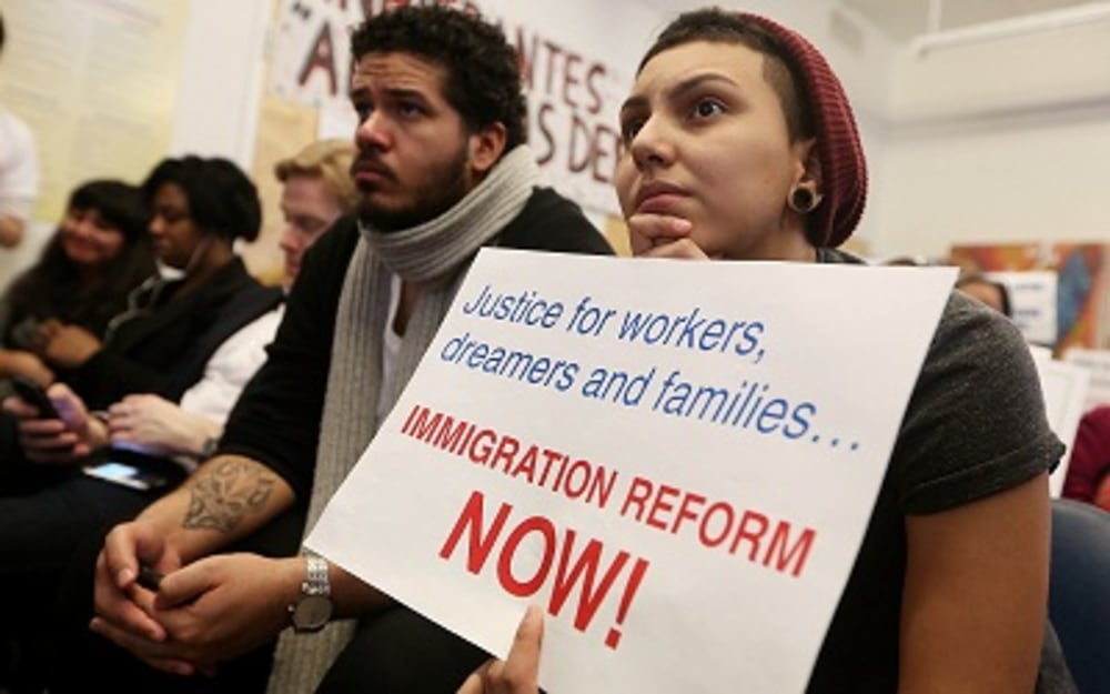 Undocumented immigrant Katherine Taberes, originally from Colombia, watches President Barack Obama's speech on immigration on January 29, 2013. (Photo by Mario Tama/Getty Images)