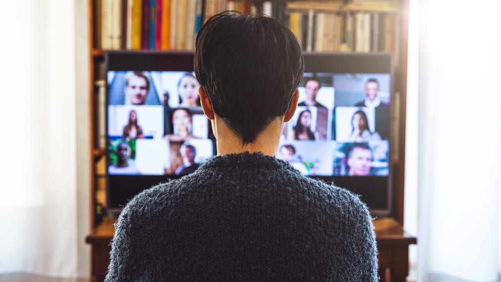 Woman in front of a device screen in video conference for work.