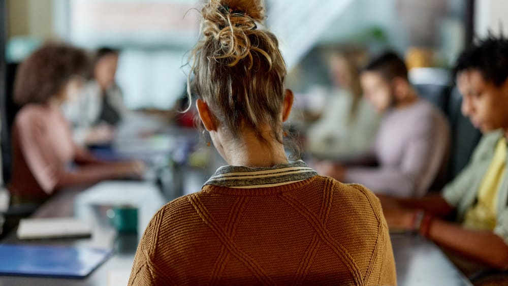 Back view of creative woman on a meeting in the office.