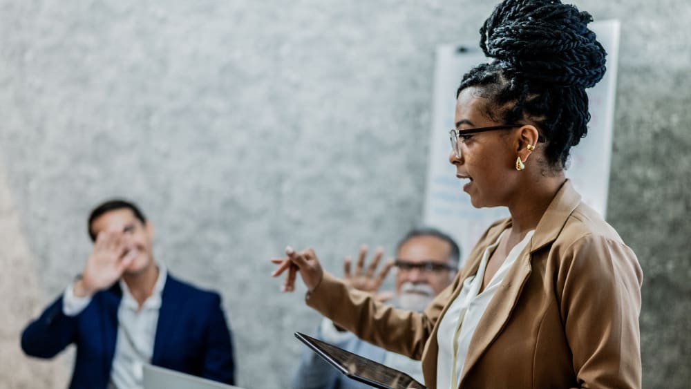 Businesswoman talking with coworkers in business meeting at office