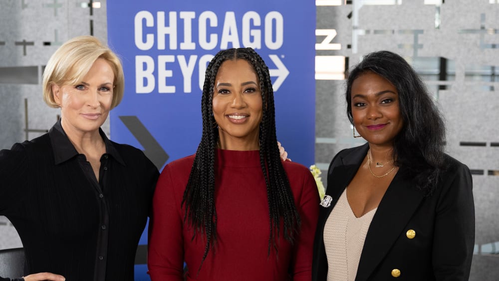 Mika Brzezinski, Liz Dozier, and Tatyana Ali in front of a Chicago Beyond sign.