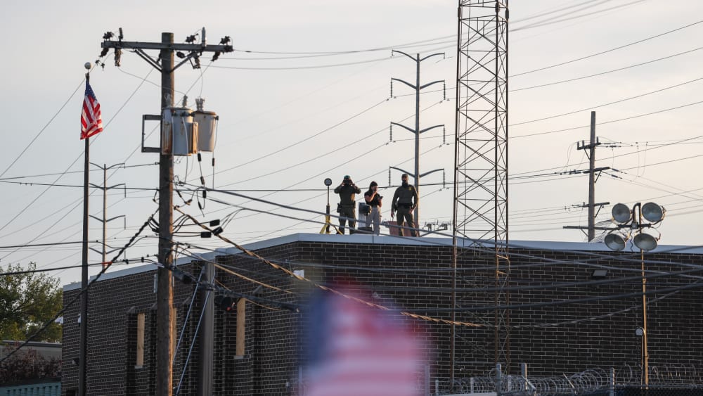 People on the roof of the immigration processing and detention center watch demonstrators in Broadview, I.L.