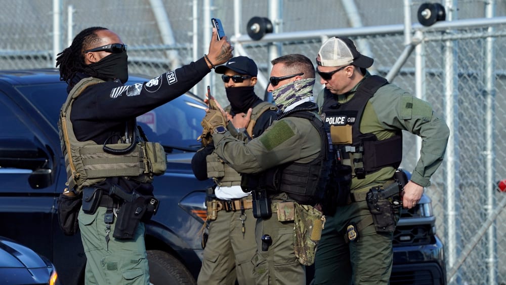 ICE agents use their phones near protestors at a demonstration in Newark, N.J. on May 7, 2025.