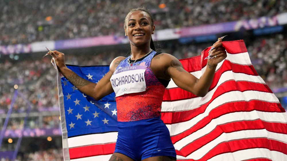 Sha'carri Richardson holds the U.S. flag.