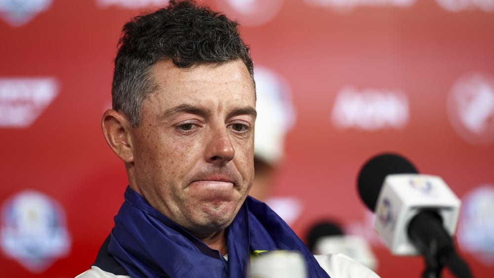 Rory McIlroy sits in front of a microphone.