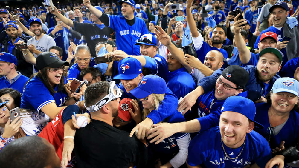 Marco Estrada #25 of the Toronto Blue Jays is swarmed by fans in Toronto, Canada.