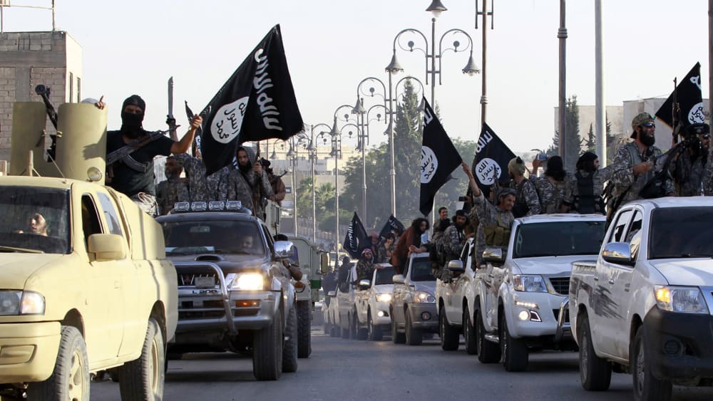 Militant Islamist fighters parade on military vehicles along the streets of northern Raqqa province June 30, 2014. (Photo by Reuters)