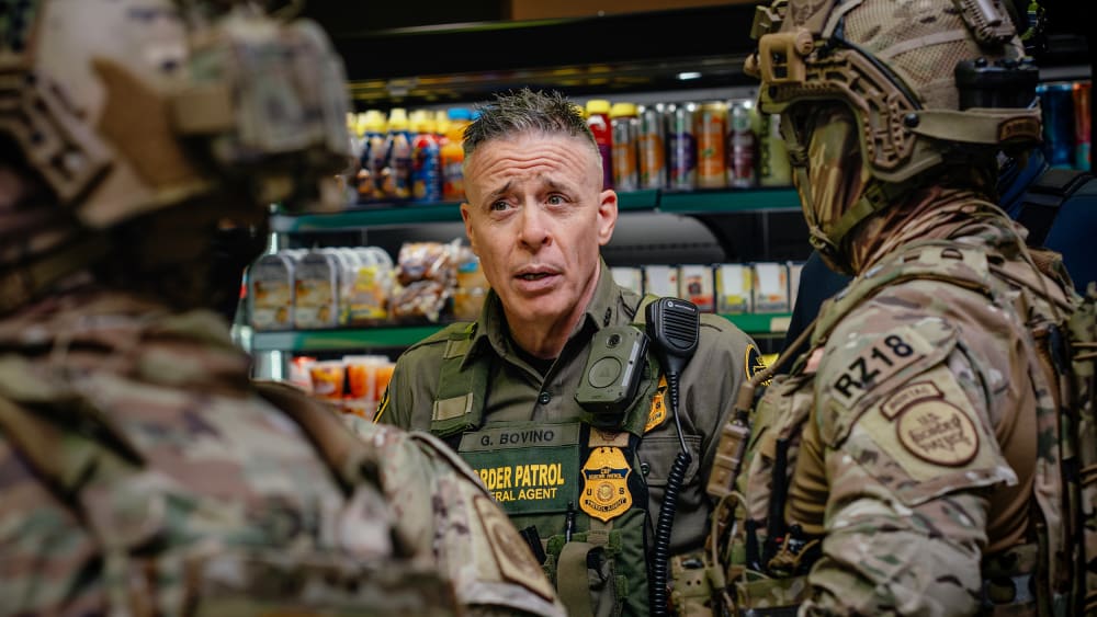 Gregory Bovino talks with other federal agents.