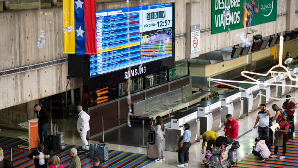 Travelers wait in line to check in for flights at the Simón Bolívar International Airport in Venezuela.