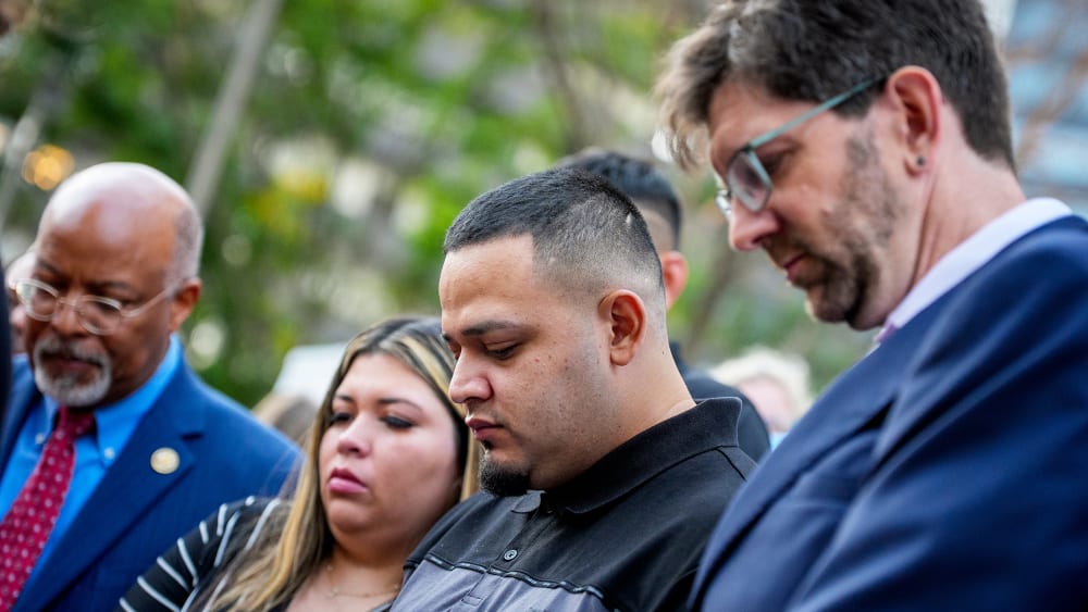 Kilmar Abrego Garcia (C), Rep. Glenn Ivey (L), Garcia's wife Jennifer Vasquez Sura (2nd-L), and his lawyer Simon Sandoval-Moshenberg (R) participates in a prayer vigil for him before he enters a U.S. Immigration and Customs Enforcement (ICE) field office.