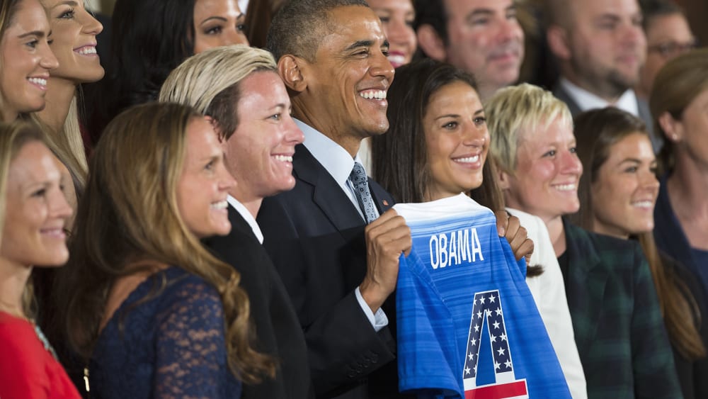 President Barack Obama holds a jersey and poses for photographs during a ceremony to honor the 2015 FIFA Women's World Cup champion U.S. National Soccer Team, Oct. 27, 2015, in the East Room of the White House in Washington, D.C. (Photo by Evan Vucci/AP)