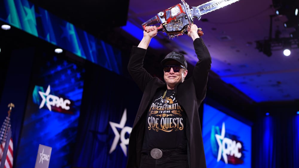 Elon Musk leaves the stage holding a chainsaw after speaking at the Conservative Political Action Conference in Oxon Hill, M.D., on Feb. 20, 2025.