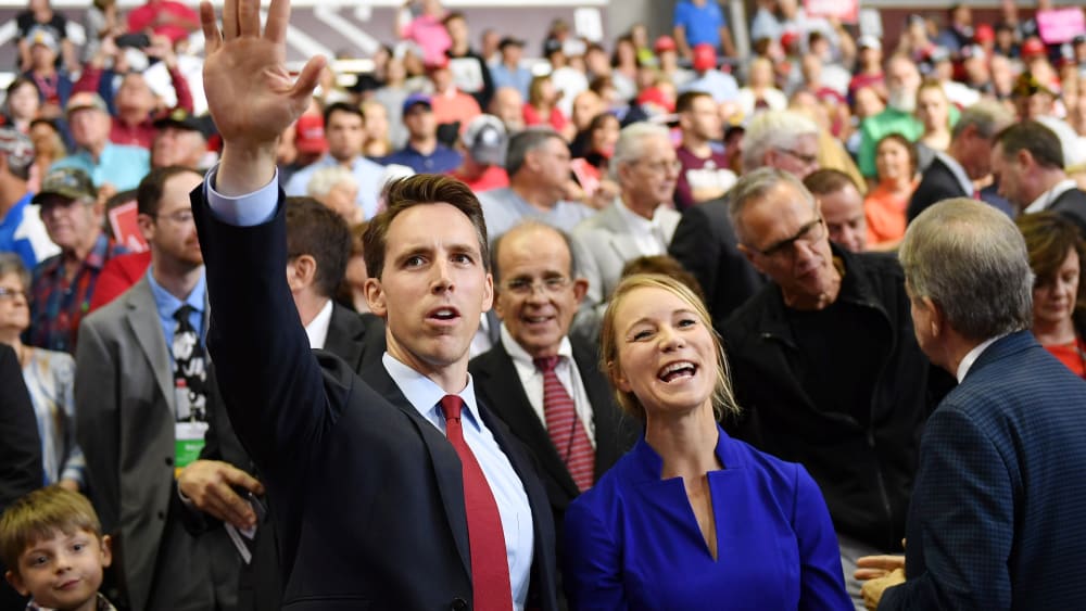 Then Missouri Attorney General Josh Hawley, left, and his wife Erin Morrow Hawley wave at a rally in Springfield, MO